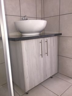 a white sink sitting on top of a wooden cabinet