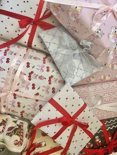 many different types of wrapping paper wrapped in red and white ribbons with bows on them