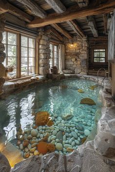 an indoor swimming pool with rocks in the water