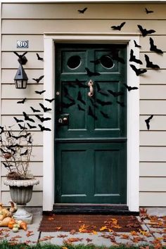 a green door decorated with bats and pumpkins