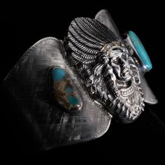 The Ute Chieftain cuff bracelet is a Sterling silver cuff with Florentine engraving & hand set Turquoise flanking a large hand cast Ute Chieftan figure. He then has a 14k yellow gold and white diamond head dress. #luxuryhardware #luxuryaccessories #luxurybuckles  #theamericanacollection #silverandgoldsmiths #silversmith #comstockheritage #gold #silver #americanmade #1886 #engraving #handengraved #beltbuckles #belts #buckles #mensfashion #mensaccessories Diamond Head, Head Dress, Tsavorite Garnet, Hand Cast, Sterling Silver Cuff, Silver Cuff, Luxury Accessories, Hand Engraving, Belt Buckle