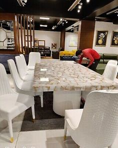 there are many white chairs around the table