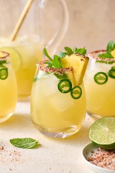 three glasses filled with drinks and garnished with limes