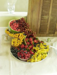 a large platter filled with lots of fruit sitting on top of a white counter