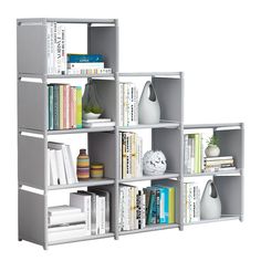 a book shelf filled with lots of books next to a white vase and other items