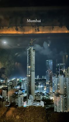 the city skyline is lit up at night with skyscrapers in the foreground and an overcast sky