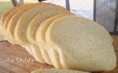 sliced white bread sitting on top of a wooden cutting board