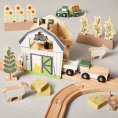 a wooden toy set with farm animals and vehicles