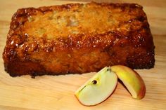 a piece of meatloaf with an apple next to it on a cutting board