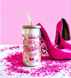 a pair of pink high heels and a can of barbie soda on a table with sprinkles