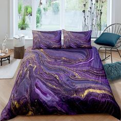 a bed covered in purple and gold marbled comforter sets next to a window