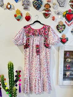 Our San Antonino dresses are unique, beautiful and perfect for any fiesta, a day at the beach or a formal event. You can easily dress it up or dress it down. Our dresses are completely hand embroidered by Artisans in Oaxaca, Mexico. It takes approximately 1 month to complete one dress.  Our San Antonino dresses are one of a kind. You will fall in love with every single detail. Each dress is hand embroidered on front chest area, sides and back with tiny floral designs inspired by the flowers in t Embroidered Short Sleeve Dress For Garden Party, Festival Floral Print Short Sleeve Dresses, Pink Ruffled Dress For Festival, Multicolor Embroidered Floral Print Short Sleeve Dress, Bohemian Pink Midi Dress With Floral Embroidery, Short Sleeve Floral Print Dress With Multicolor Embroidery, Spring Fiesta Dress With Multicolor Embroidery, Multicolor Floral Print Dress For Fiesta, Embroidered Multicolor Dress For Garden Party