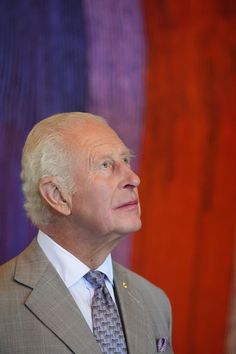 an older man in a suit and tie looking off to the side with his head tilted