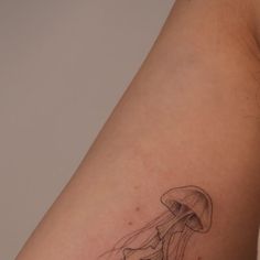 a tattoo on the arm of a woman with a jellyfish in it's mouth