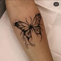 a black and white butterfly tattoo on the arm