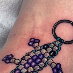 a purple and blue lizard tattoo on the leg with a black ring around it's neck