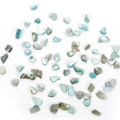 several pieces of glass sitting on top of a white surface with blue and green colors