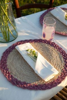 two placemats with napkins and flowers on them are sitting on a table