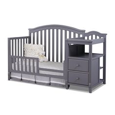 a gray crib with a white pillow on it