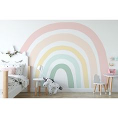 a child's bedroom with a rainbow wall mural