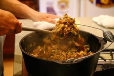 a person stirring food in a pot on the stove