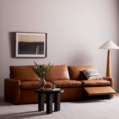 a living room filled with furniture and a lamp on top of a coffee table in front of a window