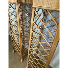 two bamboo side tables with blue sheets on them and one is leaning against the wall