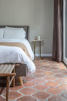 a bed sitting next to a window in a bedroom