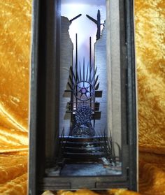 an iron throne with crosses on it in a shadow box