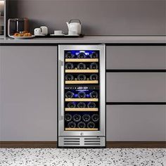 a stainless steel wine cooler in a kitchen with granite flooring and gray walls, along with white countertops