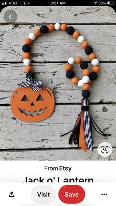 an orange and black beaded bracelet with a jack - o'- lantern on it