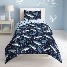 a bed room with a blue wall and a white headboard that has dolphins on it