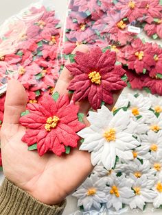 a hand is holding up some fake flowers