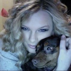 a woman holding a small dog in her arms