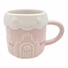 a pink and white mug with a house on it