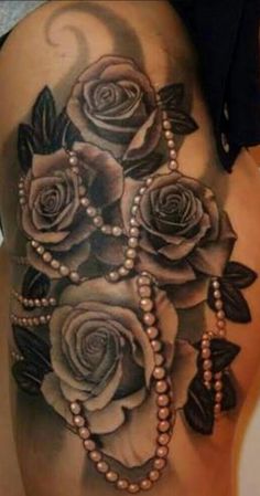 a woman's stomach with roses and pearls on it