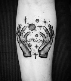 a black and white image of two hands holding an object in the air with stars around it