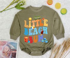 Little Beach Bum Baby Romper Sweatshirt, Retro Beach Baby Bodysuit, Summer Beach Baby Romper, Newborn Outfit - Handmade     - Ships from USA     - Materials: 100% CPSIA Compliant and Ethically Made material   Light fabric (5.0 oz/yd² (170 g/m    Crafted with soft, breathable fabric, this romper ensures your baby stays comfortable through playtimes and nap times alike. Featuring charming designs suitable for all babies, our romper is as adorable as it is practical.     Quick Sizing Tip     Our rompers are available in multiple sizes to accommodate growing babies from newborn to 24 months. To ensure the best fit, please refer to our detailed sizing chart before making a purchase.    📋 HOW TO ORDER:    ✧ Select Size: Choose the appropriate size from our dropdown menu based on our sizing char Playful Beach Tops With Cartoon Print, Playful Tops For Beach Season Playtime, Cotton Tops For Beach Season Playwear, Summer Playwear Onesie With Letter Print, Summer Graphic Print Onesie For Playwear, Fun Summer Beach Onesie, Casual Tops For Beach Season Playwear, Casual Spring Vacation Onesie, Nap Times