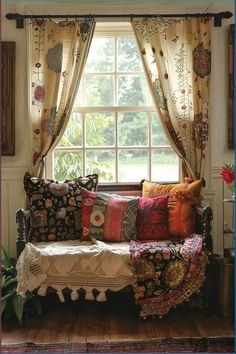 a couch sitting in front of a window covered in pillows