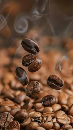 coffee beans falling into the air with steam rising from them