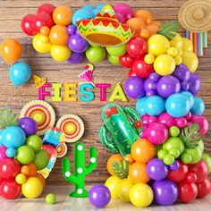 colorful fiesta party decorations and balloons on a wooden wall with the word fiesta written in large letters