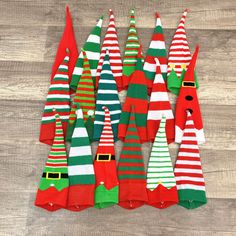 several christmas trees are lined up on a wood floor with santa's hats in the middle