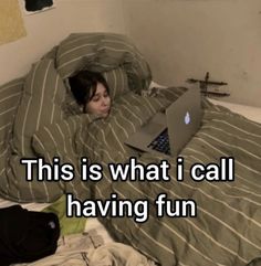 a person laying in bed with a laptop on their lap and the caption reads, this is what i call having fun