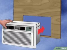 an air conditioner being held up by someone's hand and pointing at it