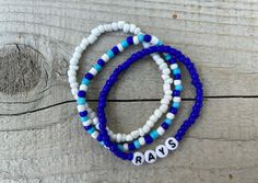 These Rays bracelets are the perfect way to show your team pride for the big game! Pair them with any outfit. This listing is for 3 bracelets as shown in pictures.  TO ORDER:  1. Pick bracelet length  2. Pick letter color 3. Submit and I'll get to work :)  PRODUCT DETAILS:  - Bracelets are made with sturdy jewelry elastic - Listing is for three bracelets  - All orders are final. Please double check your bracelet size  CARING TIPS:  - Do not expose jewelry to water  - Treat and store jewelry gently  - Roll bracelets on rather than stretching band to get on  Don't see your teams bracelets on our shop? Or have a custom team bracelet you want? Head to this link to order your custom ones!  https://kanaeohana.etsy.com/listing/1591607617/custom-sports-team-bracelets-team  We are HAPPY to do bulk Personalized Blue Bracelets For Game Day, Blue Adjustable Bracelets For Team Spirit, Blue Beaded Bracelets With Letter Beads For Team Spirit, Blue Team Spirit Jewelry For Game Day, Blue Adjustable Beaded Bracelets For Team Spirit, Casual Blue Jewelry For Game Day, Adjustable Beaded Bracelets For Game Day With School Spirit, Adjustable Team-colored Beaded Bracelets, Team Spirit Bracelets With Letter Beads