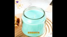 a blue candle sitting on top of a wooden table next to a plate with cookies