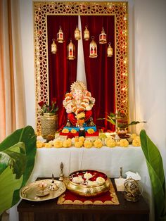 a table topped with plates and bowls filled with food next to a ganeshi idol