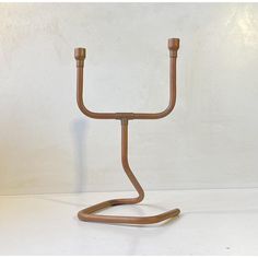 a metal candle holder with two candles on it's sides and a wooden handle