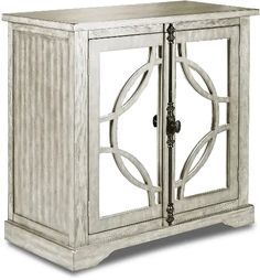 a white wooden cabinet with glass doors on the front and side panels, in an ornate pattern