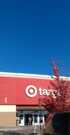 a target store with a tree in front of it and a car parked outside the building